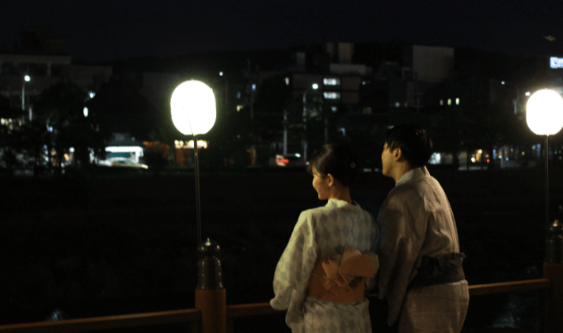 夜の鴨川を眺めるカップル